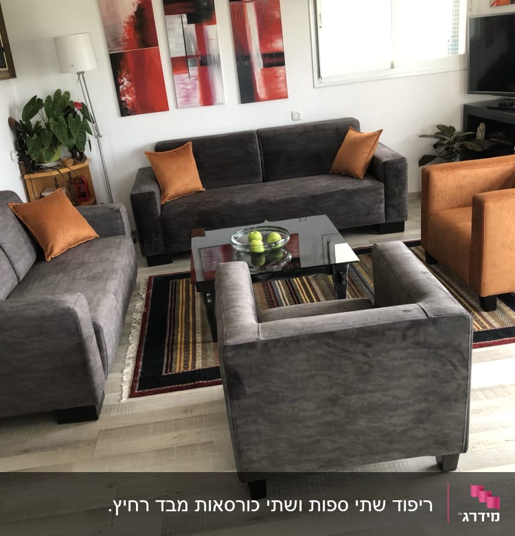 כריות כתומות על ספות אפורות בסלון מודרני